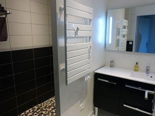 Die Weiss und Schwarz Badezimmer mit seine begehbarem Dusche
